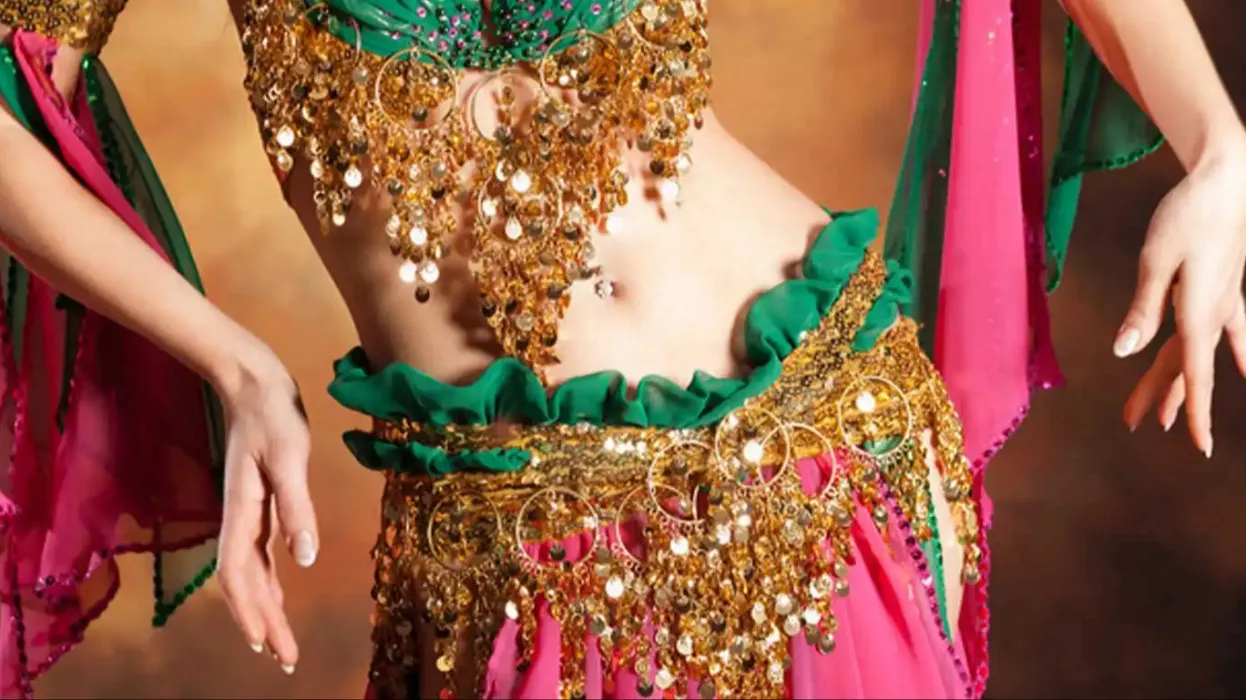A belly dancer wearing a pink and green dance costume