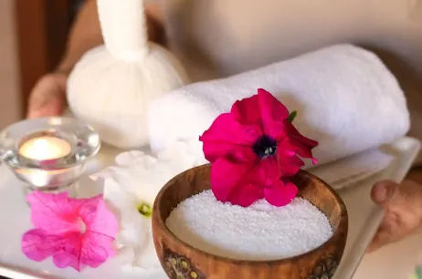 Spa products and white towel with orchids at Avitane spa in Miramar Al Aqah Resort