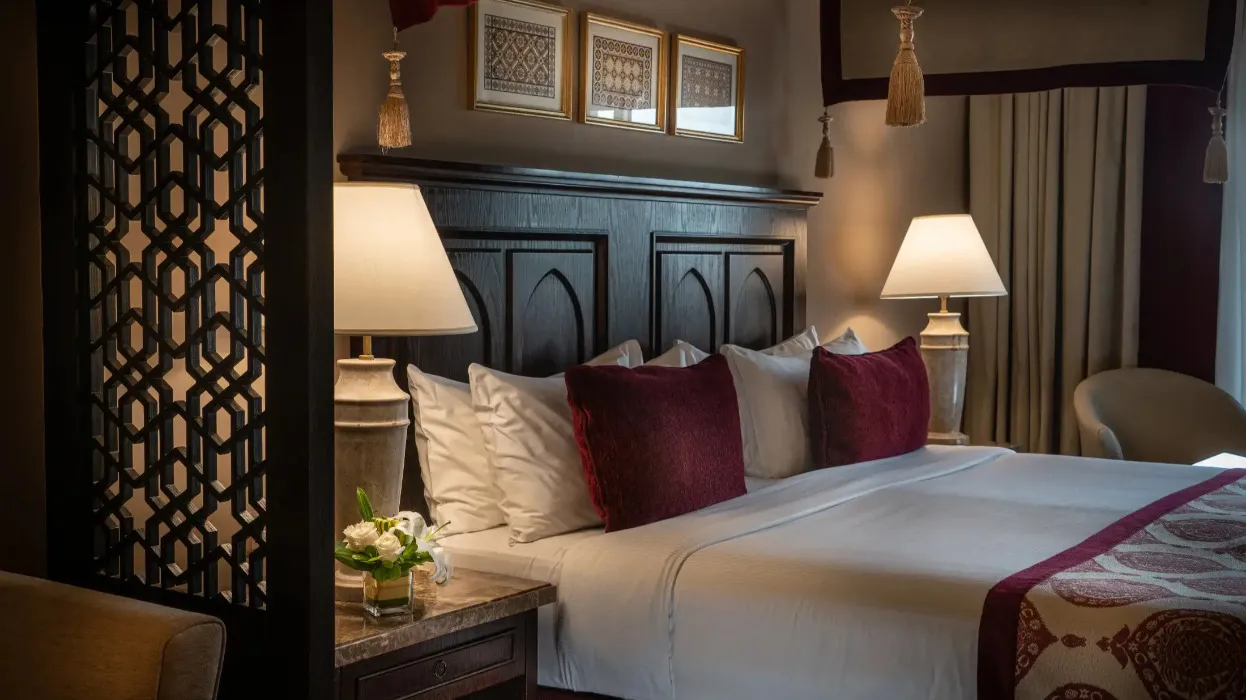 A queen size bed and table lamps at the Al Dana Suite in Miramar Al Aqah Beach Resort